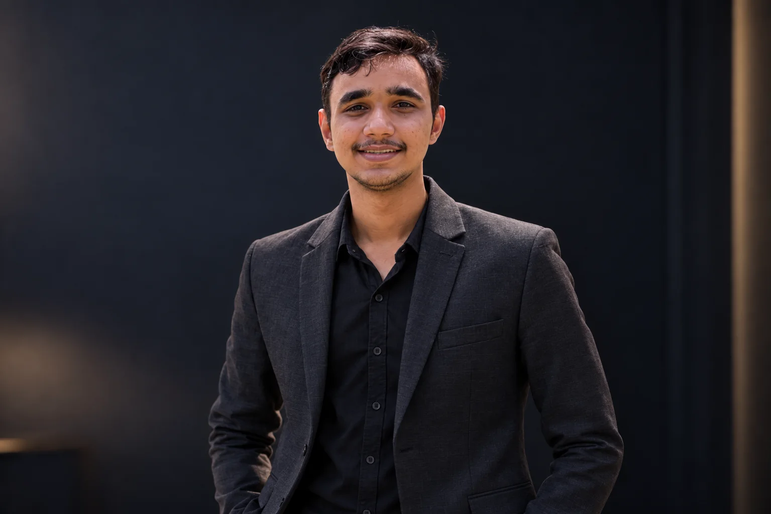 Dhananjay Sharma, founder of SHARMAG, smiling in a dark blazer